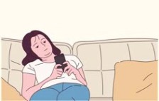 A girl is sitting on the sofa and looking at her cell phone with a boring expression.