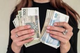양복을 입은 여성의 손에 쥐어져 있는 폴란드 화폐 100즐로티 지폐 여러 장 중 | 프리미엄 사진