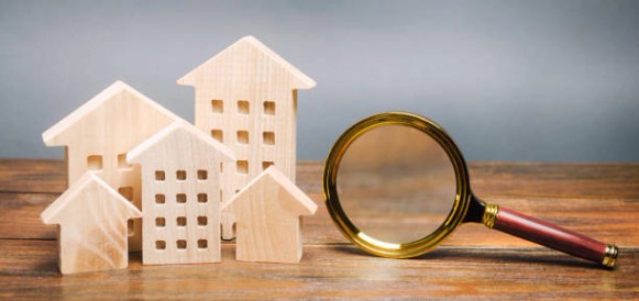 돋보기와 목조 주택. 집 검색 개념입니다. 가정 평가. 부동산 평가. 건설위치 선택. 주택, 아파트를 검색합니다. 부동산 - 아파트 투자 뉴스 사진 이미지