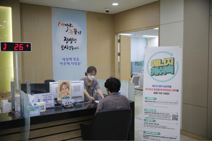 한전 지사 창구에서 에너지캐시백 신청을 돕는 직원과 신청인