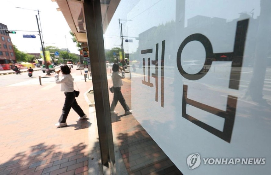 소상공인 개인회생 - 폐업 안내문이 붙은 상가 유리창과 그 앞을 지나가는 시민의 모습